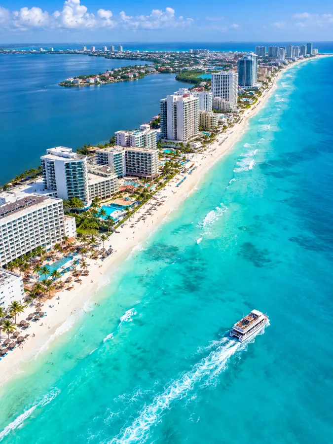 Aerial view of Cancun's Hotel Zone with a party boat on turquoise water